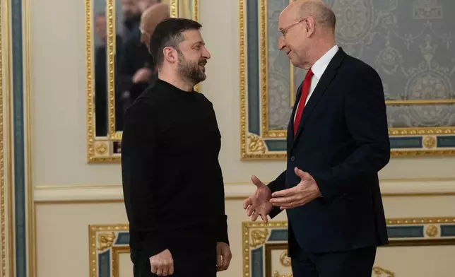 President of Ukraine Volodymyr Zelenskyy, left, and British Defense Secretary John Healey talk in Kyiv, Ukraine, Friday, Jan. 9, 2026. (AP Photo/Danylo Antoniuk)