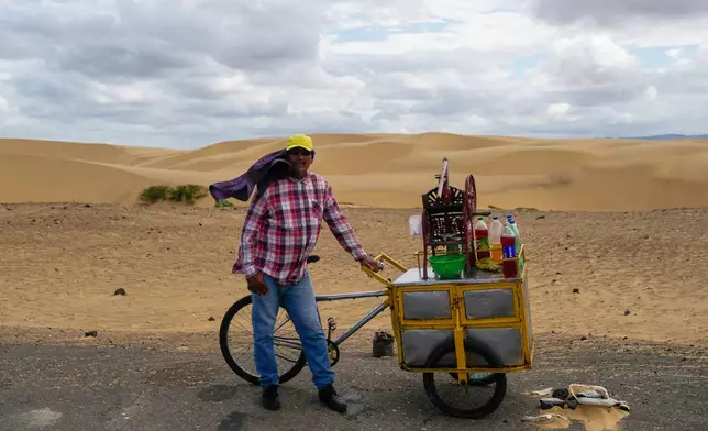 Jarrison Arias sells shaved-ice treats along the road at Medanos de Coro National Park in Venezuela, Wednesday, Jan. 14, 2026. (AP Photo/Matias Delacroix)