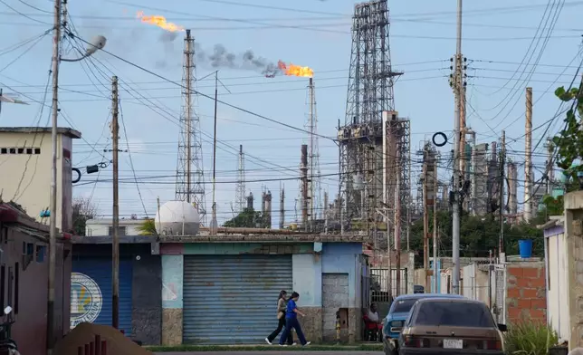 Flames rise from flare stacks at the Amuay refinery in Los Taques, Venezuela, Wednesday, Jan. 14, 2026. (AP Photo/Matias Delacroix)