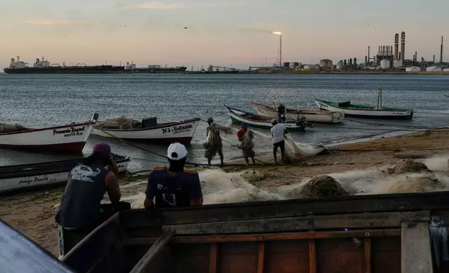 Fishermen ready the nets as oil tankers are docked at the Cardon refinery in Punta Cardon, Venezuela, Wednesday, Jan. 14, 2026. (AP Photo/Matias Delacroix)