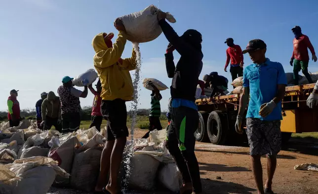 People work at the Salinas de Cumaraguas salt flats on the Paraguana Peninsula, Venezuela, Thursday, Jan. 15, 2026. (AP Photo/Matias Delacroix)
