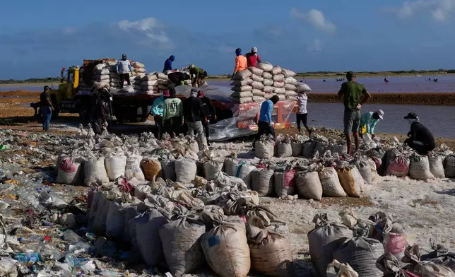 People work at the Salinas de Cumaraguas salt flats on the Paraguana Peninsula, Venezuela, Thursday, Jan. 15, 2026. (AP Photo/Matias Delacroix)