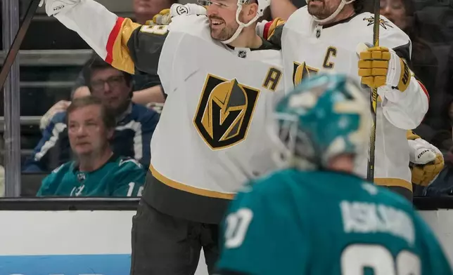 Vegas Golden Knights center Tomas Hertl, top left, celebrates with right wing Mark Stone after scoring against San Jose Sharks goaltender Yaroslav Askarov, bottom, during the second period of an NHL hockey game in San Jose, Calif., Sunday, Jan. 11, 2026. (AP Photo/Jeff Chiu)