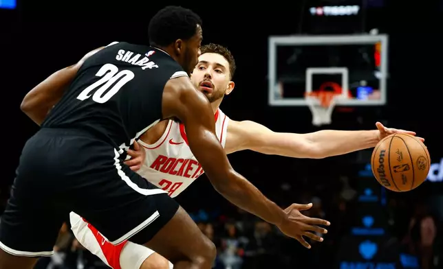 Houston Rockets center Alperen Sengun (28) handles the ball against Brooklyn Nets center Day'Ron Sharpe (20) during the first half of an NBA basketball game, Thursday, Jan. 1, 2026, in New York. (AP Photo/Noah K. Murray)