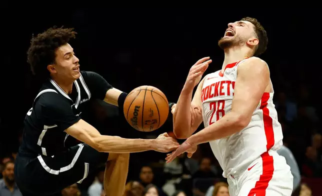 Houston Rockets center Alperen Sengun (28) is fouled by Brooklyn Nets guard Nolan Traore during the first half of an NBA basketball game, Thursday, Jan. 1, 2026, in New York. (AP Photo/Noah K. Murray)