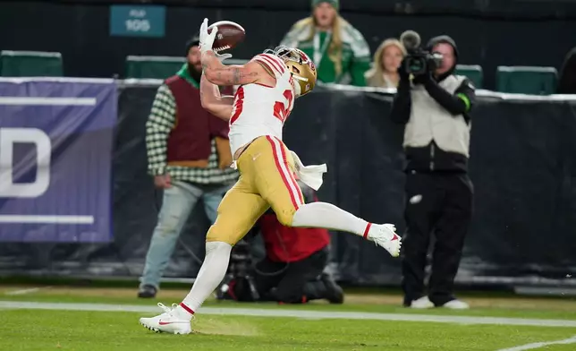 San Francisco 49ers running back Christian McCaffrey (23) catches a pass and scores a touchdown during the second half of an NFL wild-card playoff football game against the Philadelphia Eagles on Sunday, Jan. 11, 2026, in Philadelphia. (AP Photo/Chris Szagola)