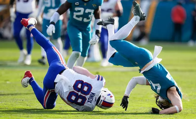 Jacksonville Jaguars safety Andrew Wingard, right, knocks down Jacksonville Jaguars tight end Patrick Herbert (88) after a reception during the second half of an NFL wild-card playoff football game Sunday, Jan. 11, 2026, in Jacksonville, Fla. (AP Photo/John Raoux)