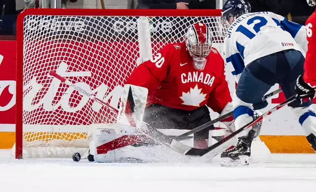 Canada goaltender Carter George (30) makes a save on Finland's Joona Saarelainen (12) during first period IIHF World Junior Championship hockey action in Minneapolis on Wednesday, Dec. 31, 2025. (Christopher Katsarov/The Canadian Press via AP)