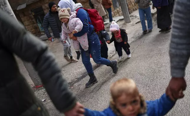 Displaced residents return to the Sheikh Maqsoud neighborhood after days of fighting between government forces and Kurdish fighters in the northern city of Aleppo, Syria, Tuesday, Jan. 13, 2026. (AP Photo/Ghaith Alsayed)
