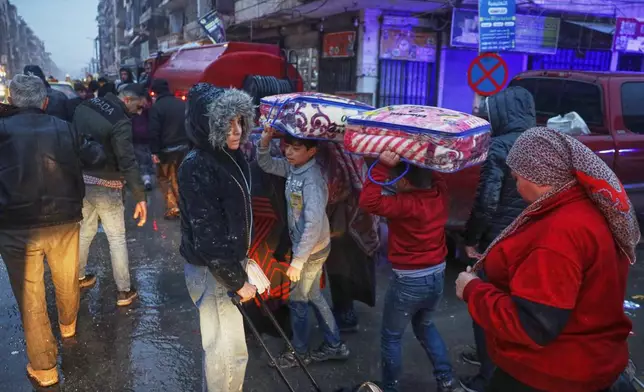 Displaced residents return to a the Achrafieh neighborhood after days of fighting between government forces and Kurdish fighters in the northern city of Aleppo, Syria, Monday, Jan. 12, 2026. (AP Photo/Omar Albam)