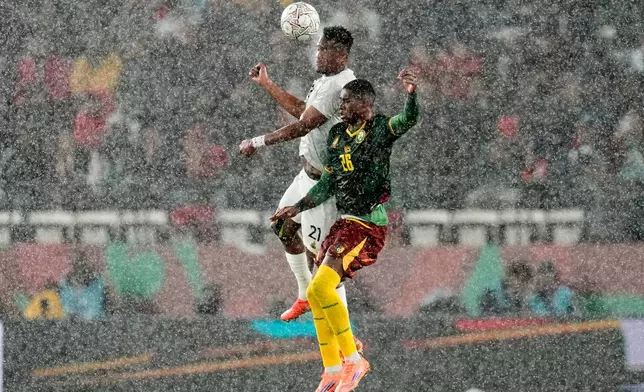South Africa's Siyabonga Ngezana and Cameroon's Christian Kofane challenge for the ball in the rain during the Africa Cup of Nations round of 16 soccer match between South Africa and Cameroon in Rabat, Morocco, Sunday, Jan. 4, 2026. (AP Photo/Themba Hadebe)