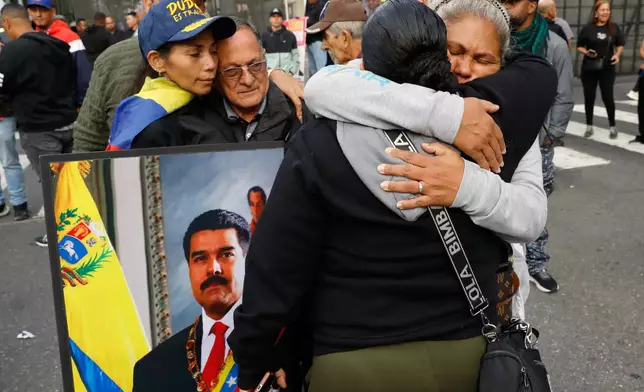 Supporters of Venezuelan President Nicolás Maduro embrace in downtown Caracas, Venezuela, Saturday, Jan. 3, 2026, after U.S. President Donald Trump announced that Maduro had been captured and flown out of the country. (AP Photo/Cristian Hernandez)