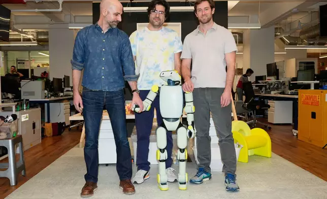 Fauna Robotics VP of hardware Anthony Moshchella, left, and co-founders Josh Merel, center, and Rob Cochran, pose for a picture with Sprout, the company's new robot, at their offices in New York, Wednesday, Jan. 14, 2026. (AP Photo/Seth Wenig)