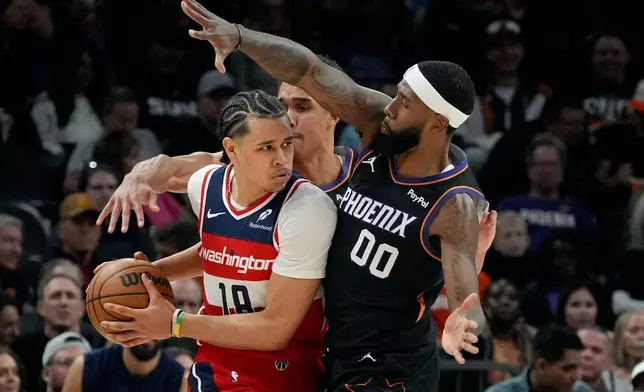 Phoenix Suns forwards Royce O'Neale (00) and Oso Ighodaro defend against Washington Wizards forward Kyshawn George (18) during the first half of an NBA basketball game, Sunday, Jan. 11, 2026, in Phoenix. (AP Photo/Ross D. Franklin)