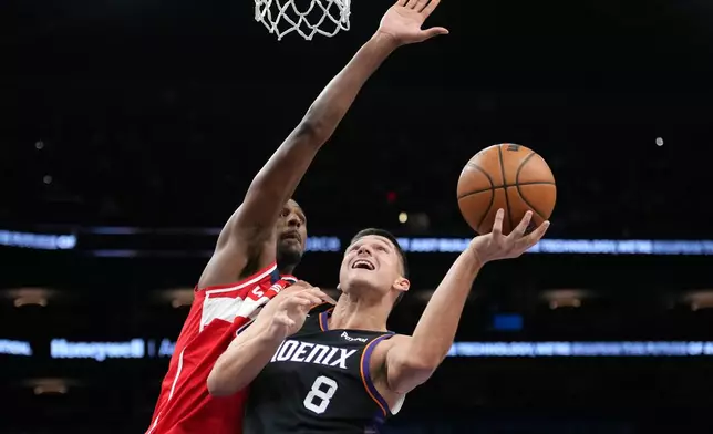 Phoenix Suns guard Grayson Allen (8) gets off a shot against Washington Wizards center Alex Sarr during the first half of an NBA basketball game, Sunday, Jan. 11, 2026, in Phoenix. (AP Photo/Ross D. Franklin)