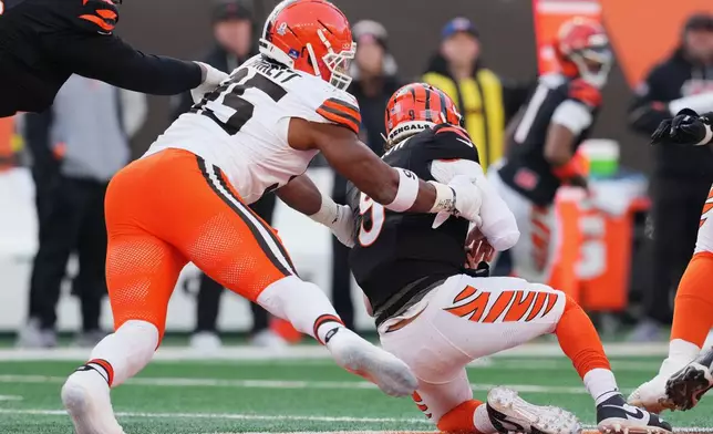 Cleveland Browns defensive end Myles Garrett, left, sacks Cincinnati Bengals quarterback Joe Burrow to set an NFL record for sacks in the regular season during the second half of an NFL football game, Sunday, Jan. 4, 2026, in Cincinnati. (AP Photo/Jeff Dean)