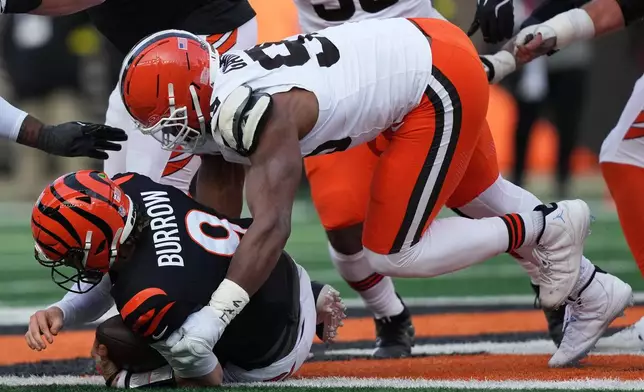 Cleveland Browns defensive end Myles Garrett, top, sacks Cincinnati Bengals quarterback Joe Burrow (9) to set an NFL record for sacks in the regular season during the second half of an NFL football game, Sunday, Jan. 4, 2026, in Cincinnati. (AP Photo/Joshua A. Bickel)