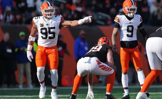 Cleveland Browns defensive end Myles Garrett (95) gestures at the line of scrimmage next to safety Grant Delpit (9) during the first half of an NFL football game against the Cincinnati Bengals, Sunday, Jan. 4, 2026, in Cincinnati. (AP Photo/Jeff Dean)