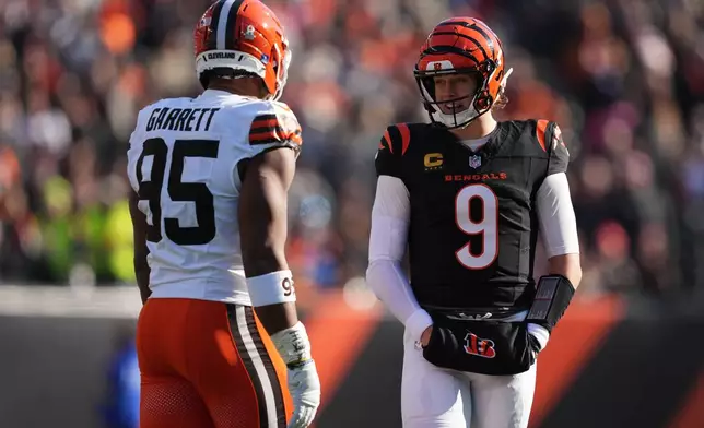 Cleveland Browns defensive end Myles Garrett (95) talks with Cincinnati Bengals quarterback Joe Burrow (9) during the first half of an NFL football game, Sunday, Jan. 4, 2026, in Cincinnati. (AP Photo/Joshua A. Bickel)