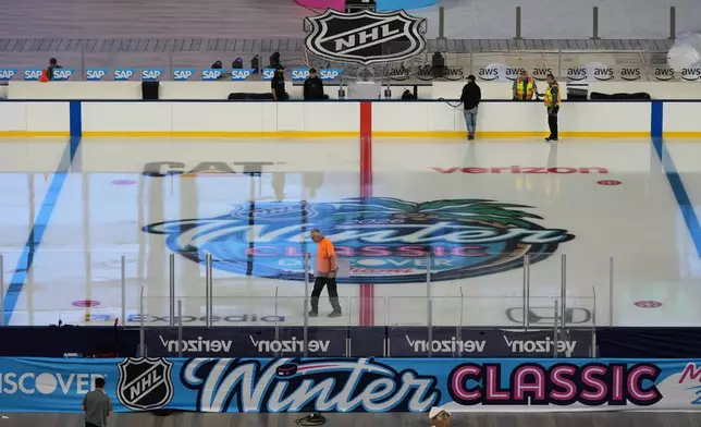 Workers prepare the ice for the upcoming NHL Winter Classic hockey game between the Florida Panthers and New York Rangers, Tuesday, Dec. 30, 2025, at loanDepot Park in Miami. (AP Photo/Lynne Sladky)
