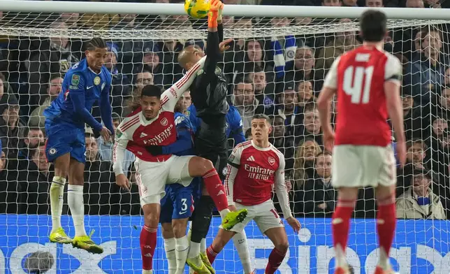 Chelsea's goalkeeper Robert Sanchez, center, tries to catch the ball during the English League Cup semifinal first leg soccer match between Chelsea and Arsenal in London, Wednesday, Jan. 14, 2026. (AP Photo/Alastair Grant)