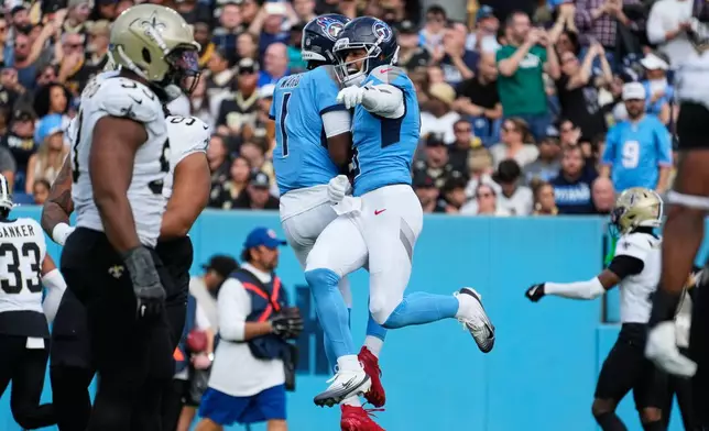 Tennessee Titans wide receiver Elic Ayomanor (5) celebrates his touchdown reception with quarterback Cam Ward (1) in the first half of an NFL football game against the New Orleans Saints, Sunday, Dec. 28, 2025, in Nashville, Tenn. (AP Photo/George Walker IV)