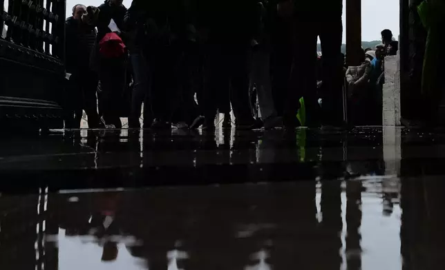 FILE - Pilgrims cross through the Holy Door of St. Peter Basilica at the Vatican, Jan. 5, 2026. (AP Photo/Alessandra Tarantino, File)