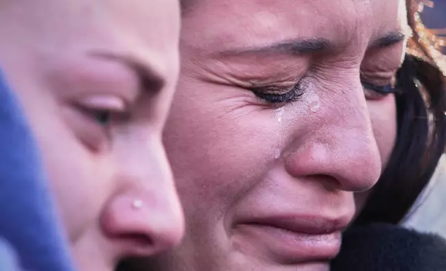 FILE - People cry during a memorial procession in Crans-Montana, Swiss Alps, Switzerland, Jan. 4, 2026, after a deadly bar fire during the New Year celebrations. (AP Photo/ Antonio Calanni, File)