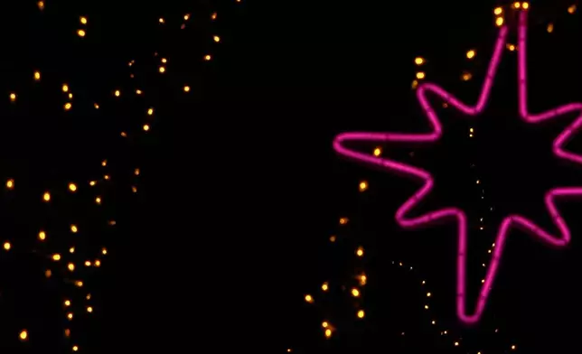 FILE - The Wolf Supermoon rises in the distance behind decorative holiday lights in Beijing, Jan. 2, 2026. (AP Photo/Andy Wong, File)