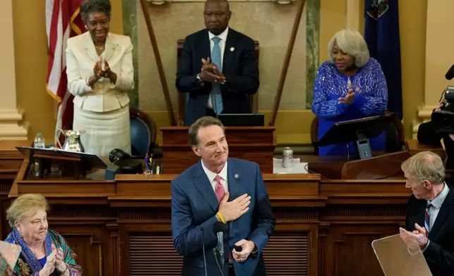 Virginia Gov. Glenn Youngkin acknowledges the applause as he delivers his State of the Commonwealth Address during the opening of the 2026 session of the General Assembly at the Capitol in Richmond, Va., Wednesday, Jan. 14, 2026. Lt. Gov. Winsome Earl-Sears, top left, House Speaker, Don Scott, D-Portsmouth, top center, and Senate President Pro ten, Louise Lucas, D-Portsmouth, join in the welcome. (AP Photo/Steve Helber)