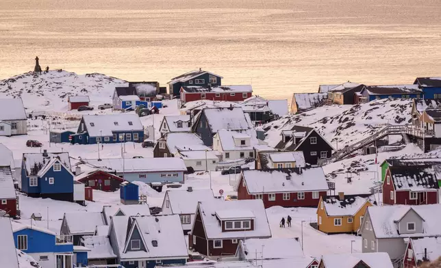People walk on a street in Nuuk, Greenland, Wednesday, Jan. 14, 2026. (AP Photo/Evgeniy Maloletka)