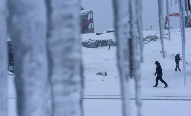 People walk through the snow in Nuuk, Greenland, Monday, Jan. 19, 2026. (AP Photo/Evgeniy Maloletka)