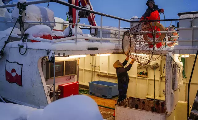 Fishermen load crab trap into a boat at the harbour of Nuuk, Greenland, on Monday, Jan. 19, 2026. (AP Photo/Evgeniy Maloletka)