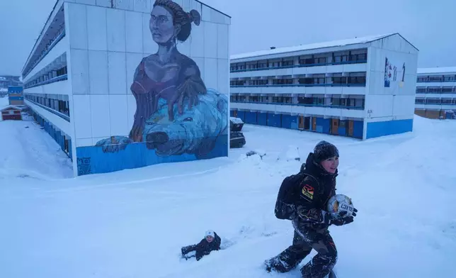Boys play with a ball in the snow in Nuuk, Greenland, Monday, Jan. 19, 2026. (AP Photo/Evgeniy Maloletka)
