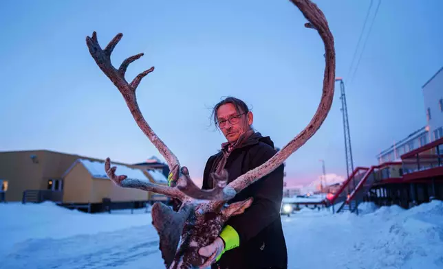 John Hansen, 61, holds a reindeer's head with antlers in Nuuk, Greenland, on Wednesday, Jan. 21, 2026. (AP Photo/Evgeniy Maloletka)