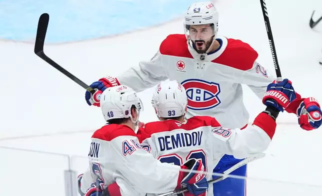 Montréal Canadiens defenseman Lane Hutson (48) celebrates after his overtime goal with right wing Ivan Demidov (93) and center Phillip Danault (24) during an NHL hockey game against the Dallas Stars, Sunday, Jan. 4, 2026, in Dallas. (AP Photo/LM Otero)