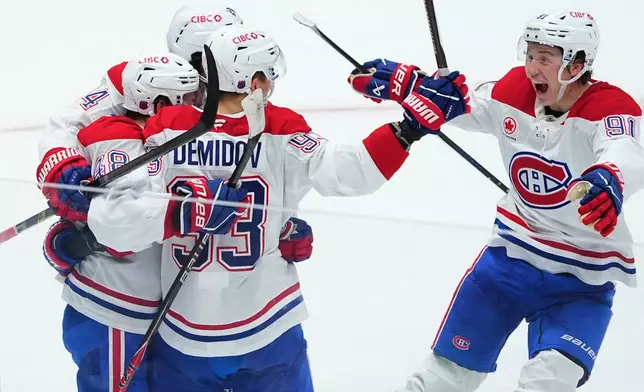 Montréal Canadiens defenseman Lane Hutson (48) celebrates after his overtime goal with right wing Ivan Demidov (93), center Phillip Danault (24) and center Oliver Kapanen (91) during an NHL hockey game against the Dallas Stars, Sunday, Jan. 4, 2026, in Dallas. (AP Photo/LM Otero)