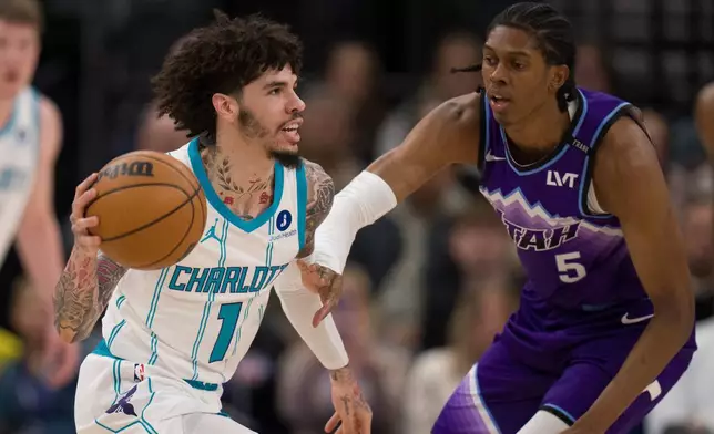 Charlotte Hornets guard LaMelo Ball (1) looks to pass the ball as Utah Jazz forward Cody Williams (5) defends during the first half of an NBA basketball game, Saturday, Jan. 10, 2026, in Salt Lake City. (AP Photo/Bethany Baker)