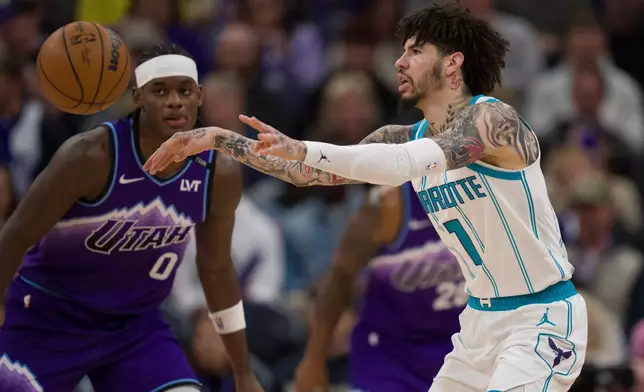 Charlotte Hornets guard LaMelo Ball (1) passes the ball as he is defended by Utah Jazz forward Taylor Hendricks (0) during the first half of an NBA basketball game, Saturday, Jan. 10, 2026, in Salt Lake City. (AP Photo/Bethany Baker)