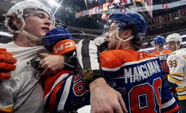 Boston Bruins' Fraser Minten (93) and Edmonton Oilers' Andrew Mangiapane (88) rough it up during the second period of an NHL hockey game, in Edmonton, Alberta, Wednesday, Dec. 31, 2025. (Jason Franson/The Canadian Press via AP)