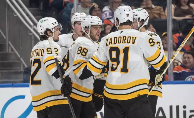 Boston Bruins David Pastrnak (88) celebrates a goal with teammates against the Edmonton Oilers during the third period of an NHL hockey game, in Edmonton, Alberta, Wednesday, Dec. 31, 2025. (Jason Franson/The Canadian Press via AP)