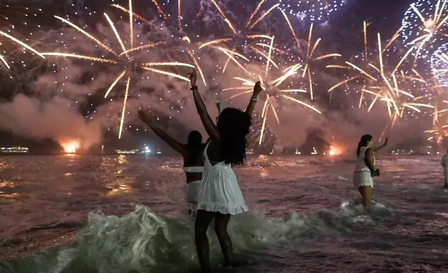 FILE - People celebrate as fireworks light up the sky over Copacabana Beach during New Year's celebrations in Rio de Janeiro, Jan. 1, 2026. (AP Photo/Bruna Prado, File)