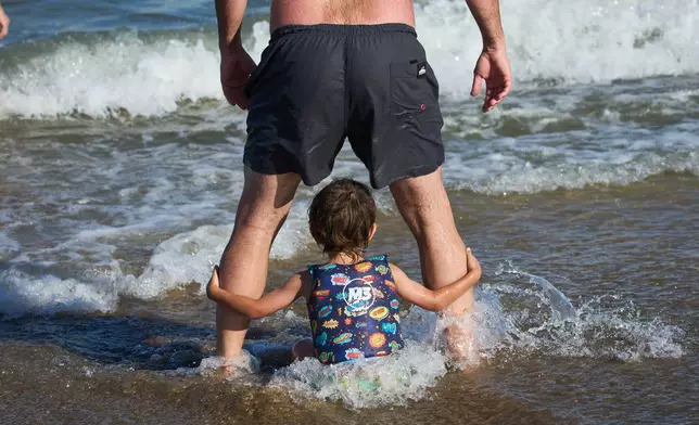 FILE - People spend time on the beach in Carilo, Buenos Aires province, Argentina, Dec. 28, 2025. (AP Photo/Rodrigo Abd, File)