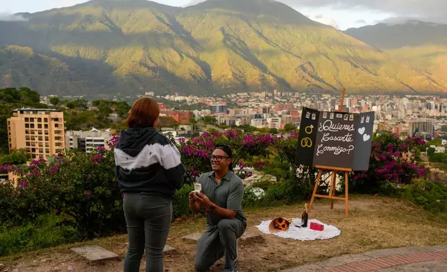 FILE - Jose Saavedra proposes to his girlfriend Mariele Munoz at the Valle Arriba viewpoint in Caracas, Venezuela, Dec. 30, 2025. (AP Photo/Matias Delacroix, File)