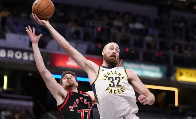 Indiana Pacers center Jay Huff (32) saves a ball from going out of bounds in front of Toronto Raptors forward Jamison Battle (77) during the first half of an NBA basketball game in Indianapolis, Wednesday, Jan. 14, 2026. (AP Photo/AJ Mast)