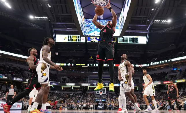 Toronto Raptors forward Scottie Barnes (4) dunks in front of Indiana Pacers guard Aaron Nesmith (23) during the first half of an NBA basketball game in Indianapolis, Wednesday, Jan. 14, 2026. (AP Photo/AJ Mast)