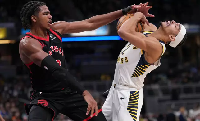 Indiana Pacers guard Andrew Nembhard, right, is fouled by Toronto Raptors forward Collin Murray-Boyles during the first half of an NBA basketball game in Indianapolis, Wednesday, Jan. 14, 2026. (AP Photo/AJ Mast)