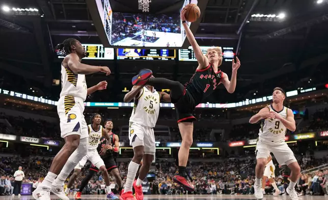 Toronto Raptors guard Gradey Dick (1)pulls down a rebound in front of Indiana Pacers guard T.J. McConnell (9) during the first half of an NBA basketball game in Indianapolis, Wednesday, Jan. 14, 2026. (AP Photo/AJ Mast)