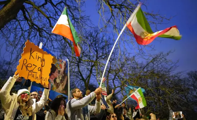 Protesters hold up placards and flags as they demonstrate outside the Iranian Embassy in London, Monday, Jan. 12, 2026. (AP Photo/Alastair Grant)