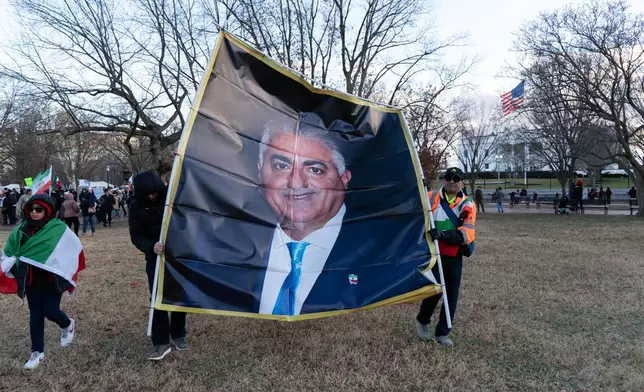 Activists carrying a photograph of Reza Pahlavi take part in a rally supporting protesters in Iran at Lafayette Park, across from the White House, in Washington, Sunday, Jan. 11, 2026. (AP Photo/Jose Luis Magana)